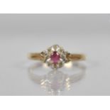 A 9ct Gold, Diamond and Ruby Cluster Ring, Oval Cut Ruby Measuring 3.9mm by 2.8mm Set in Four