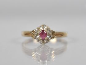 A 9ct Gold, Diamond and Ruby Cluster Ring, Oval Cut Ruby Measuring 3.9mm by 2.8mm Set in Four