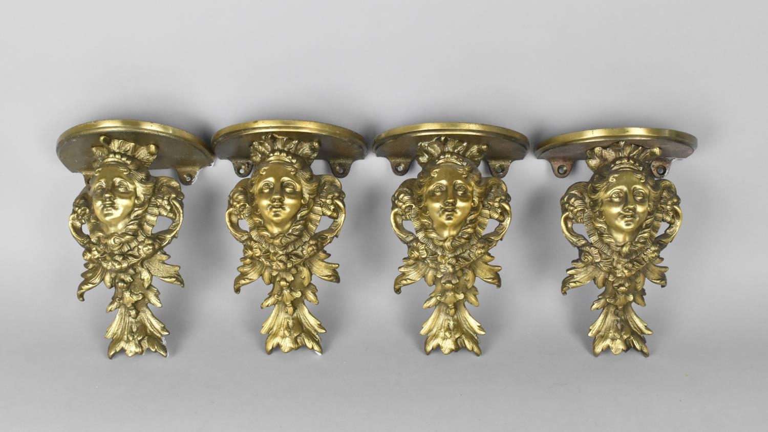 A Set of Four Cast Brass Wall Sconces Modelled with Maidens Head Amongst Foliage and Acanthus