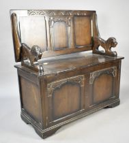 A Mid 20th Century Monks Bench with Carved Lion Arm Rests and Two Panelled Front, Hinged Seat, 95cms