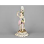 A 19th Century German Porcelain Figural Candlestick Modelled as a Lady Holding Basket of Flowers and