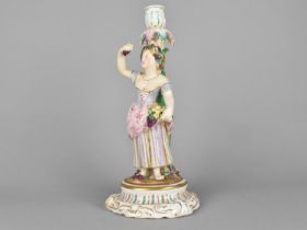 A 19th Century German Porcelain Figural Candlestick Modelled as a Lady Holding Basket of Flowers and