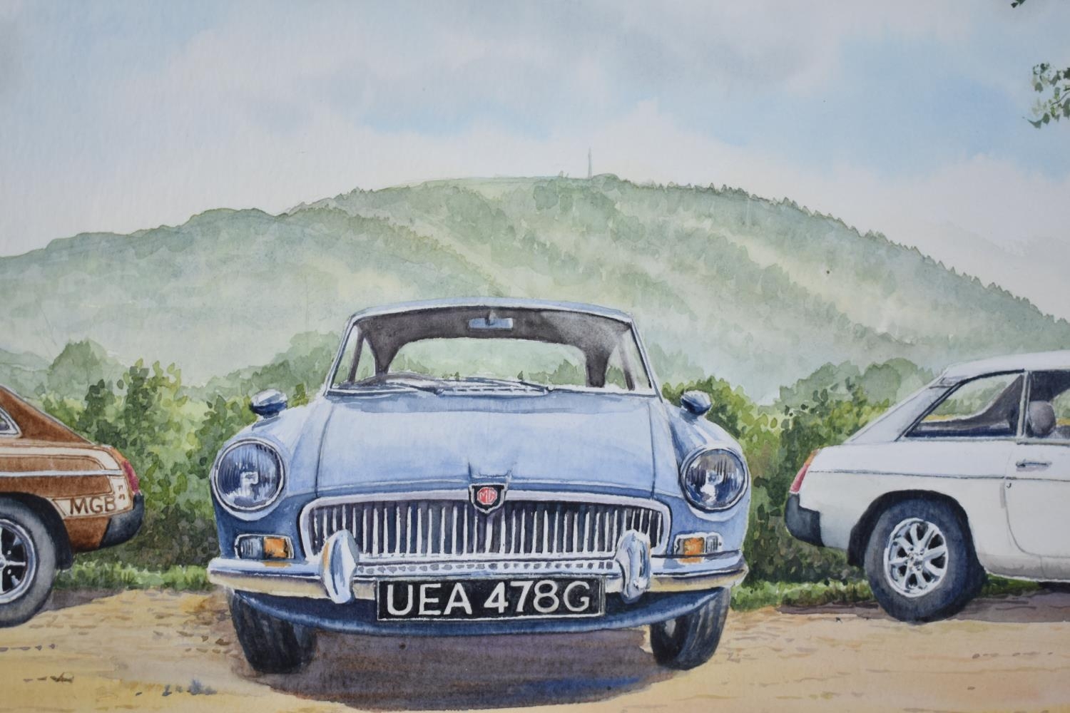 A Framed Watercolour Depicting Three MGB Motorcars in front of the Wrekin, 73x32cms, Monogrammed RGS - Image 2 of 2
