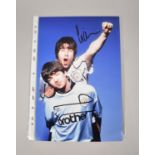 A Photograph of the Gallagher Brothers, Signed by Liam, of Oasis
