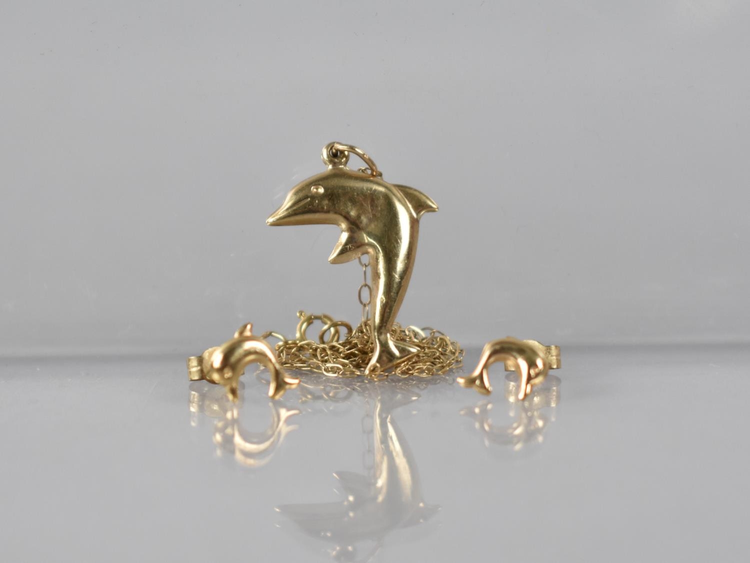 A Suite of 9ct Gold Jewellery, Dolphins, to include a pair of Earrings and Pendant on Chain, 0.8gms