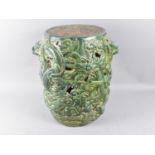 A Chinese Glazed Stoneware Cylindrical Seat with Heavy Relief Decoration Depicting Dragons, 30cms