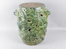 A Chinese Glazed Stoneware Cylindrical Seat with Heavy Relief Decoration Depicting Dragons, 30cms