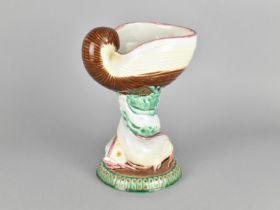 A Majolica Glazed Centrepiece Modelled with Shell Bowl on Dolphin Supports, 23cm high