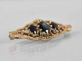 A 9ct Gold and Sapphire Brooch, Central Oval Cut Stone Measuring 7.9x6.1mm, Raised in Ten Claws to a