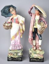A Pair of Continental Glazed Figural Ornaments, Gent with Basket of Fish and Lady with Basket of