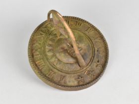 A Circular Cast Metal Sundial Top Decorated with Half Portraits of Sun and Moon, 19cms Diameter