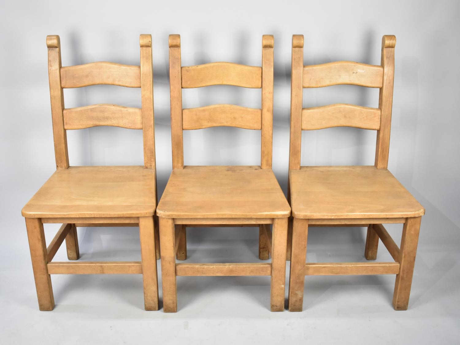 A Set of Three Hardwood Ladder Back Dining Chairs