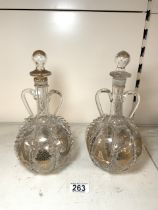 PAIR OF DUTCH GLASS TWO HANDLED DECANTERS WITH GILT DECORATION WITHIN MOULDED BORDERS, 27CM.