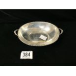 EDWARDIAN HALLMARKED SILVER OVAL TWO HANDLED DISH WITH HUSK DECORATED BORDER ON PIERCED FEET.