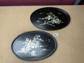 TWO WOODEN BLACK OVAL PLAQUES DECORATED WITH MOTHER OF PEARL 37CM