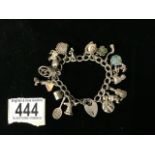 A SILVER CHARM BRACELET; THE PADLOCK STAMPED SILVER; WITH VARIOUS CHARMS INCLUDING A WINDMILL, AN