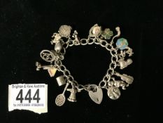 A SILVER CHARM BRACELET; THE PADLOCK STAMPED SILVER; WITH VARIOUS CHARMS INCLUDING A WINDMILL, AN