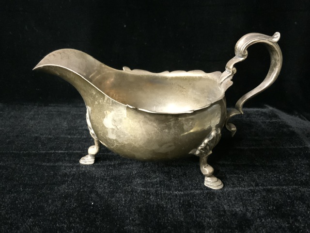 A STERLING SILVER SAUCEBOAT; SHEFFIELD 1923; SCROLL HANDLE; WAVY EDGE; ON THREE SHELL AND HOOF FEET; - Image 2 of 4