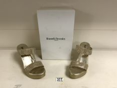 A PAIR OF RUSSELL & BROMLEY GOLD WEDGE HEEL SLIP ON SHOES; SIZE 38 UK 5; TEXTURED SIDES AND FABRIC