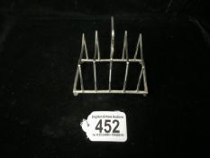AN EDWARDIAN STERLING SILVER FIVE BAR TOASTRACK BY W.H.HASELER; BIRMINGHAM 1906; SHAPED LOOP HANDLE;