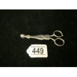 A PAIR OF GEORGIAN STERLING SILVER SCISSOR ACTION SUGAR NIPS; MARKS TO HANDLES RUBBED; LION