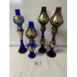 FOUR MURANO COLOURED GLASS DECORATIVE OIL LAMPS; 33CM