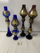 FOUR MURANO COLOURED GLASS DECORATIVE OIL LAMPS; 33CM