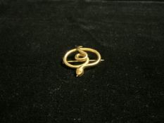 A 15 CARAT GOLD BROOCH, ENGRAVED TO REVERSE '15 CT', IN THE FORM OF A CURLED SNAKE, TOTAL WEIGHT 4