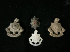 THREE THE ROYAL SUSSEX REGIMENT CAP BADGES, TWO PLASTIC EXAMPLES AND ONE MOTHER OF PEARL AND A