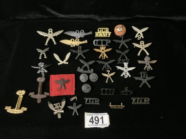 A QUANTITY OF MOSTLY GURKHA RIFLES, METAL MILITARY CAP BADGES, ALSO VARIOUS SHOULDER TITLES AND