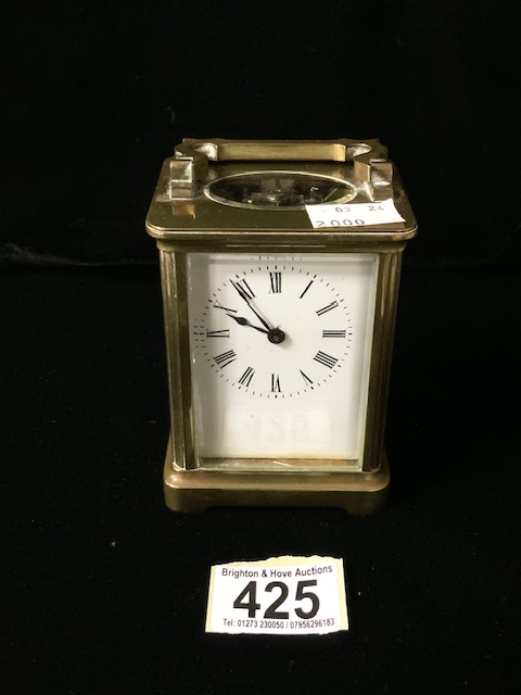 A VINTAGE BRASS AND GLASS CASED CARRIAGE CLOCK; SCROLL HANDLE; ROMAN NUMERALS; HEIGHT 10CM