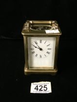 A VINTAGE BRASS AND GLASS CASED CARRIAGE CLOCK; SCROLL HANDLE; ROMAN NUMERALS; HEIGHT 10CM