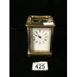 A VINTAGE BRASS AND GLASS CASED CARRIAGE CLOCK; SCROLL HANDLE; ROMAN NUMERALS; HEIGHT 10CM