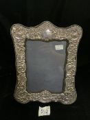A LARGE STERLING SILVER MOUNTED PHOTOGRAPH FRAME; LONDON 1987; SHAPED RECTANGULAR FORM, EMBOSSED