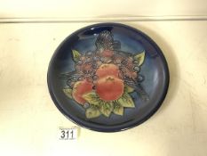 MOORCROFT; A FINCHES AND FRUIT PATTERN PLATE / CHARGER DESIGNED BY SALLY TUFFIN, ON DARK BLUE