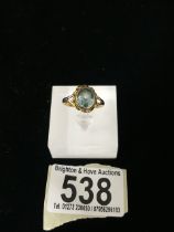A VINTAGE 9 CARAT GOLD AND AQUAMARINE DRESS RING; STAMPED '9CT', STONE OF OVAL FORM, IN A ROPE TWIST