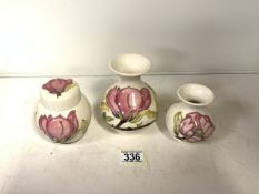 MOORCROFT: THREE MAGNOLIA PATTERN PIECES, COMPRISING; A LIDDED GINGER JAR AND TWO BALUSTER VASES
