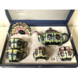 MOORCROFT: A CASED VIOLET PATTERN TEA SET AND PAIR OF CUPS AND SAUCERS DESIGNED BY SALLY TUFFIN