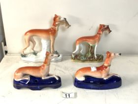 FOUR 19TH CENTURY HUNTING DOG / WHIPPET / GREYHOUND FIGURINES, TWO HOLDING A CATCH AND A PAIR IN A