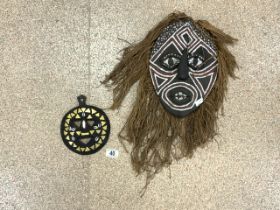TWO TRIBAL MASKS, ONE MODELLED AS A FACE WITH HAIR; FEATURES AND FACE PAINT, THE OTHER SMALLER AND