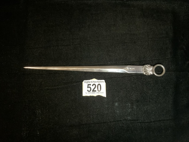 A STERLING SILVER LETTER OPENER; LONDON 1958; IN THE FORM OF A MEAT SKEWER; WITH SHELL AND RING