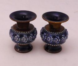 A pair of Doulton miniature vases of squat circular form on raised circular bases, decorated with