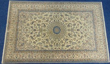 A Persian silk and wool carpet cream ground with central medallion surrounded by repeating flowers