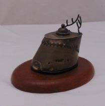 An inkstand in the form of a horses hoof with silver plated mounts on raised oval wooden plinth,