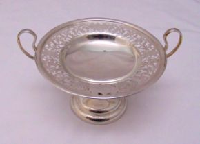 A hallmarked silver cake stand circular scroll pierced with looped side handles on raised circular