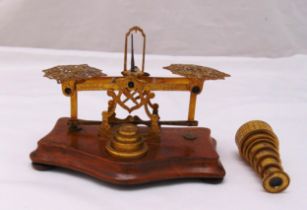 A brass letter scale and weights mounted on a walnut plinth and a miniature seven draw brass
