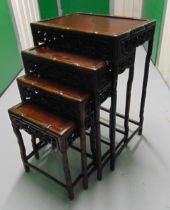 A Chinese hardwood four part nest of stacking tables shaped rectangular, scroll pierced sides on