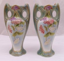 A pair of early 20th century French ceramic vases decorated with flowers and leaves, marks to the