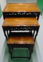 An oriental hardwood nest of three rectangular tables with pierced galleries and simulated bamboo