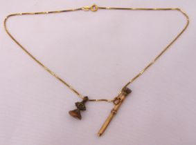 A 9ct gold chain with a miniature propelling pencil pendant and a seal pendant, approx total